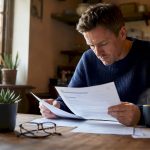 UK homeowner reviewing mortgage documents at kitchen table