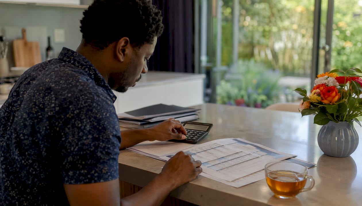 Hands calculating bathroom finance options on printed table