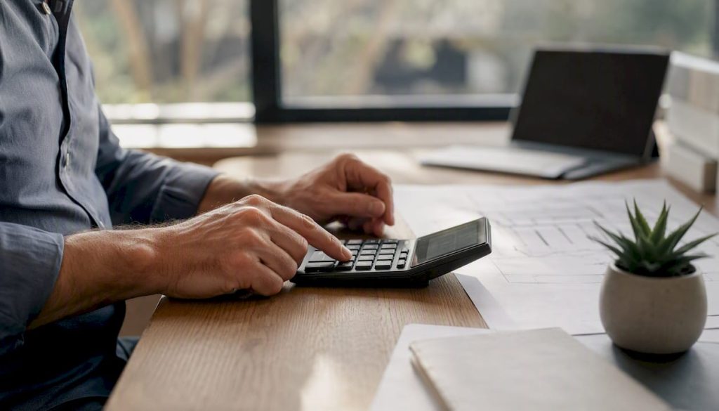 Hands using calculator for loan calculations